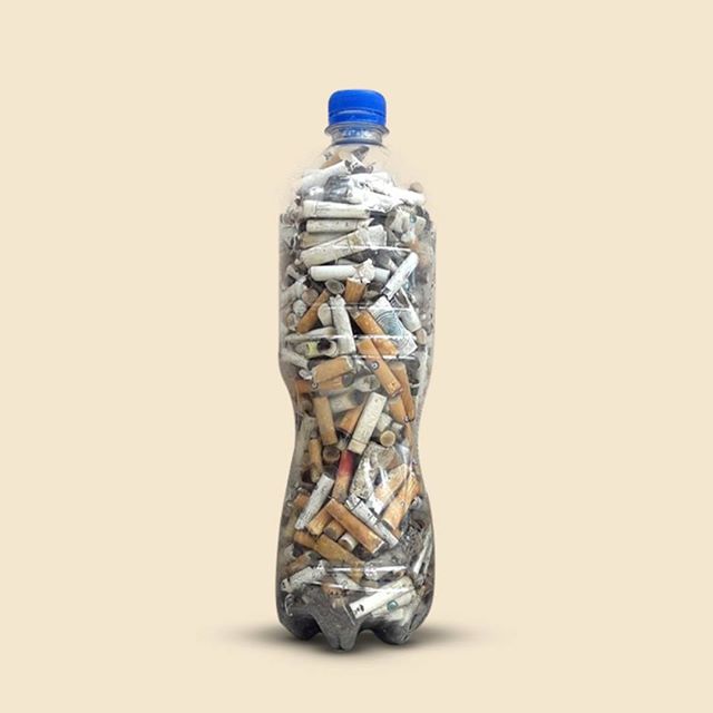 A clear plastic bottle filled with cigarette butts