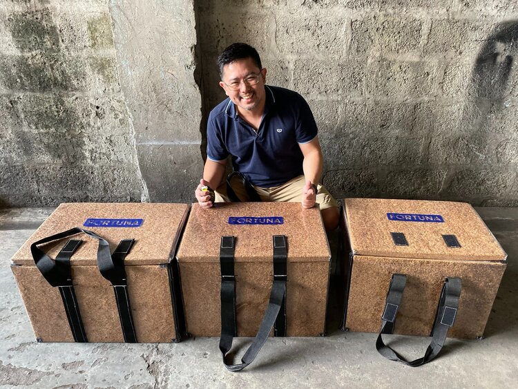 A food distributor kneeling behind three of Fortuna's coconut coolers