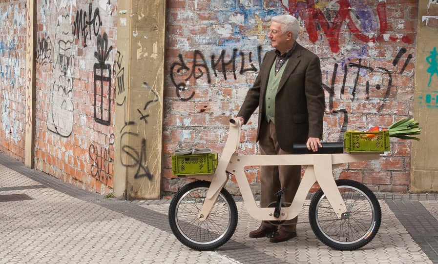 Older man with a wooden bike with groceries in attached baskets