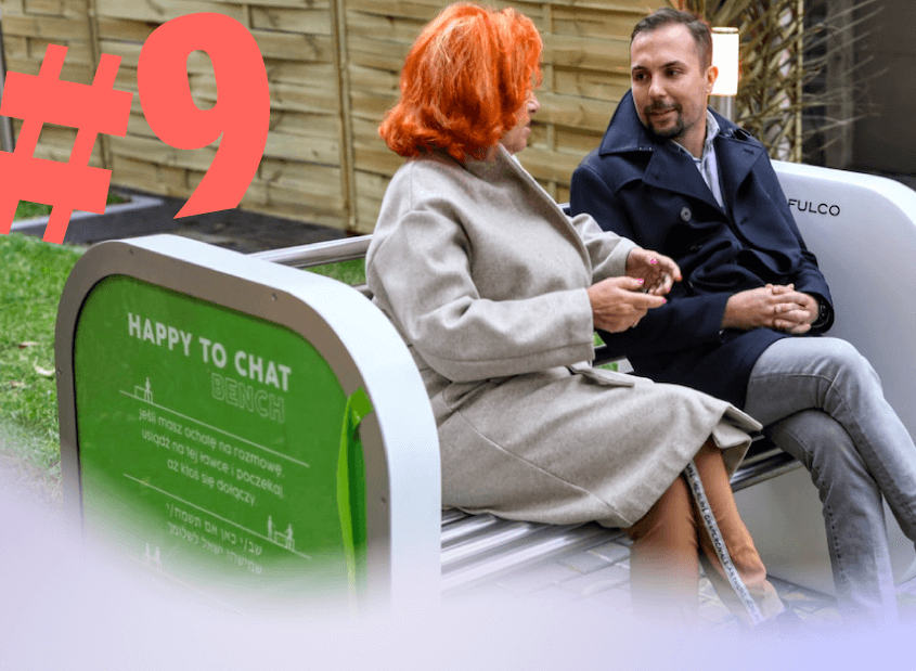 Two people talking on a 'happy-to-chat' bench