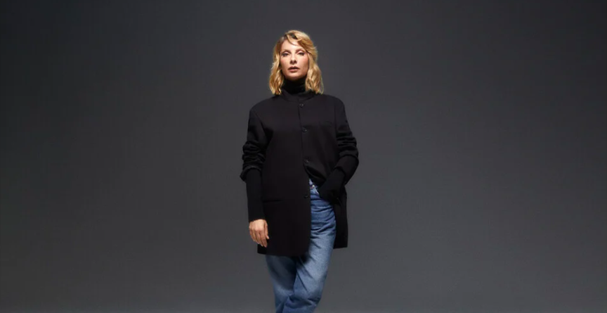 Woman wearing blue jeans with a black turtleneck and jacket
