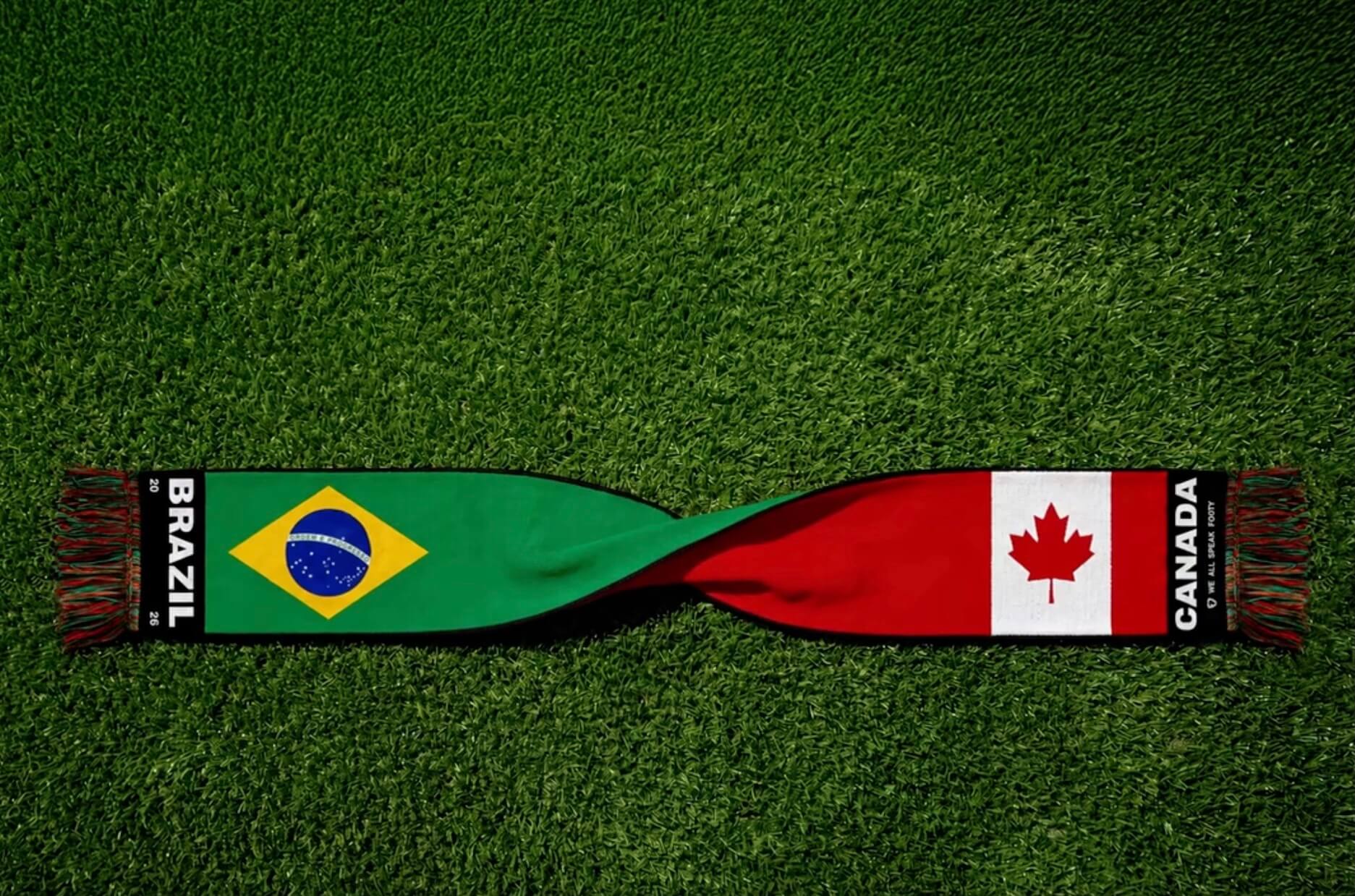 A dual-sided football scarf laid on grass, featuring the Brazilian flag and 
