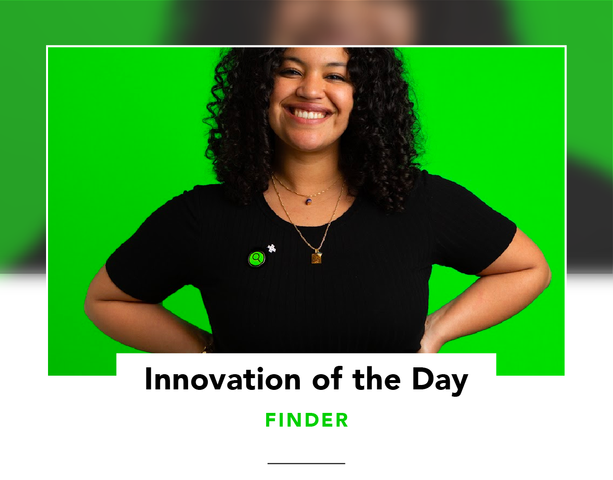 Woman with curly hair wearing a bright green pin on a black shirt