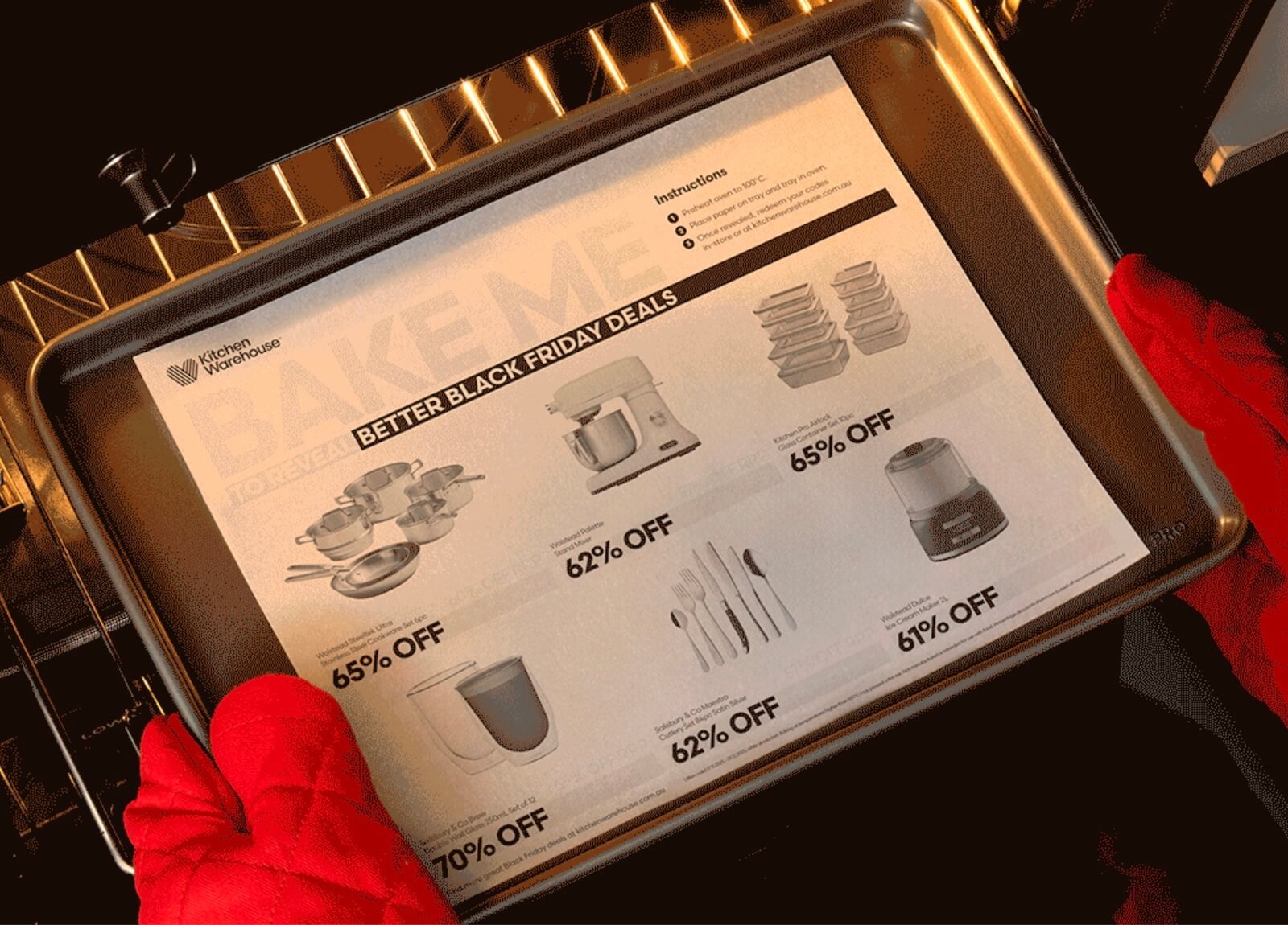 Red oven mitts slide a baking tray into an oven, holding a heat-activated Kitchen Warehouse “Bake Friday” sheet that reveals Black Friday discounts 