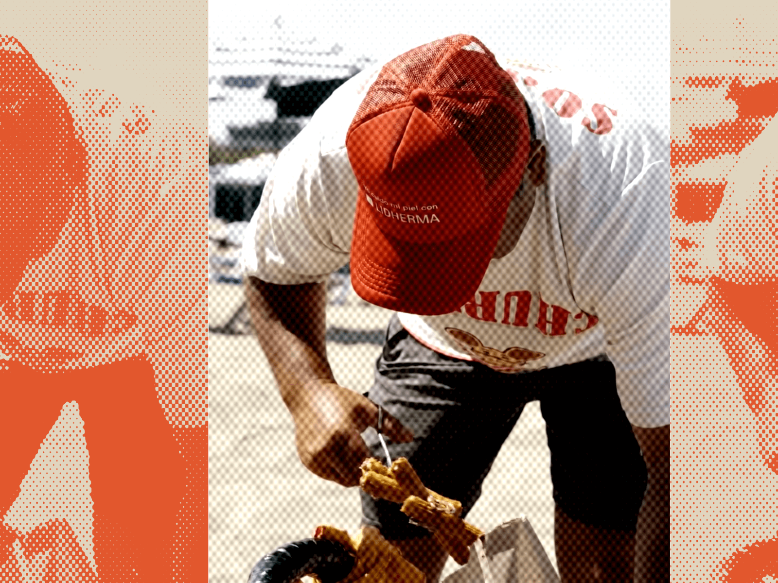 A churro vendor on an Argentine beach wearing a red Lidherma-branded cap and a white Churros t-shirt, bending over a basket of churros 