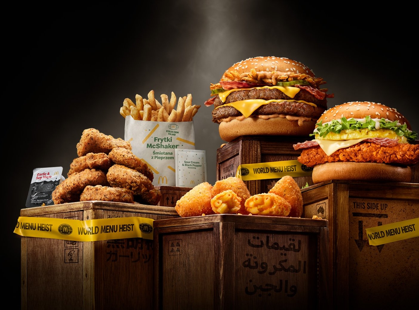 A promotional image for McDonald’s UK “World Menu Heist” campaign, featuring international menu items displayed on wooden crates wrapped in yellow “World Menu Heist” tape 