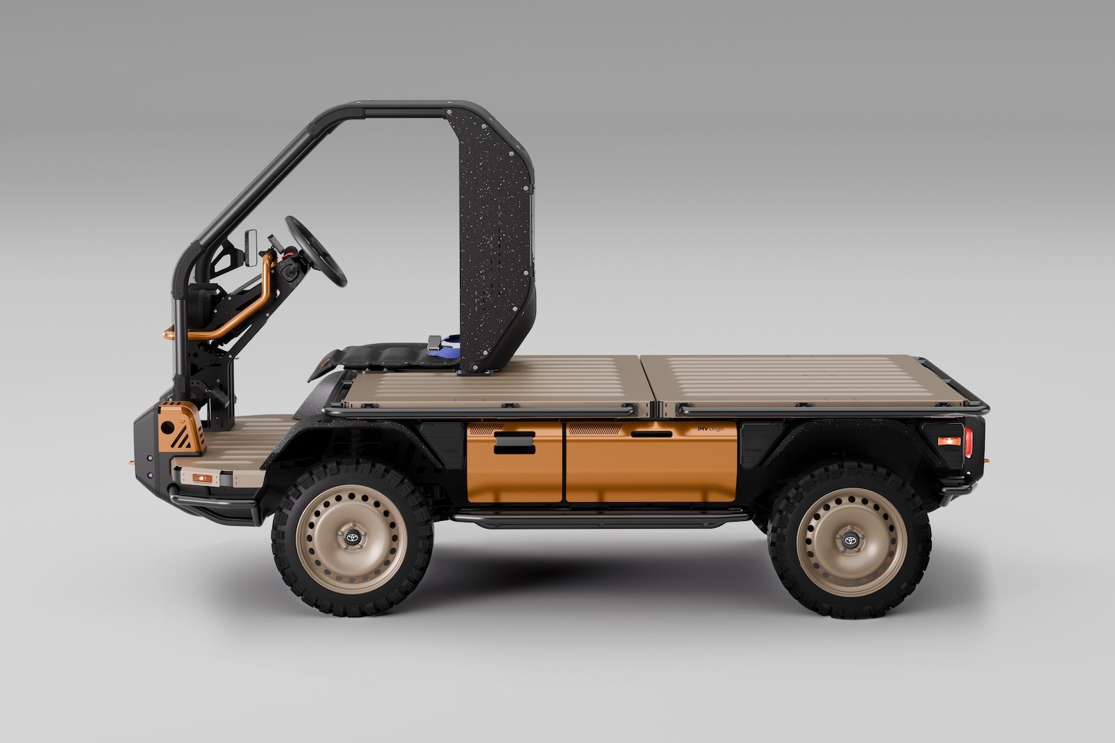 A rugged Toyota utility vehicle with an open cab, flatbed back and barebones design, finished in matte black and bronze 