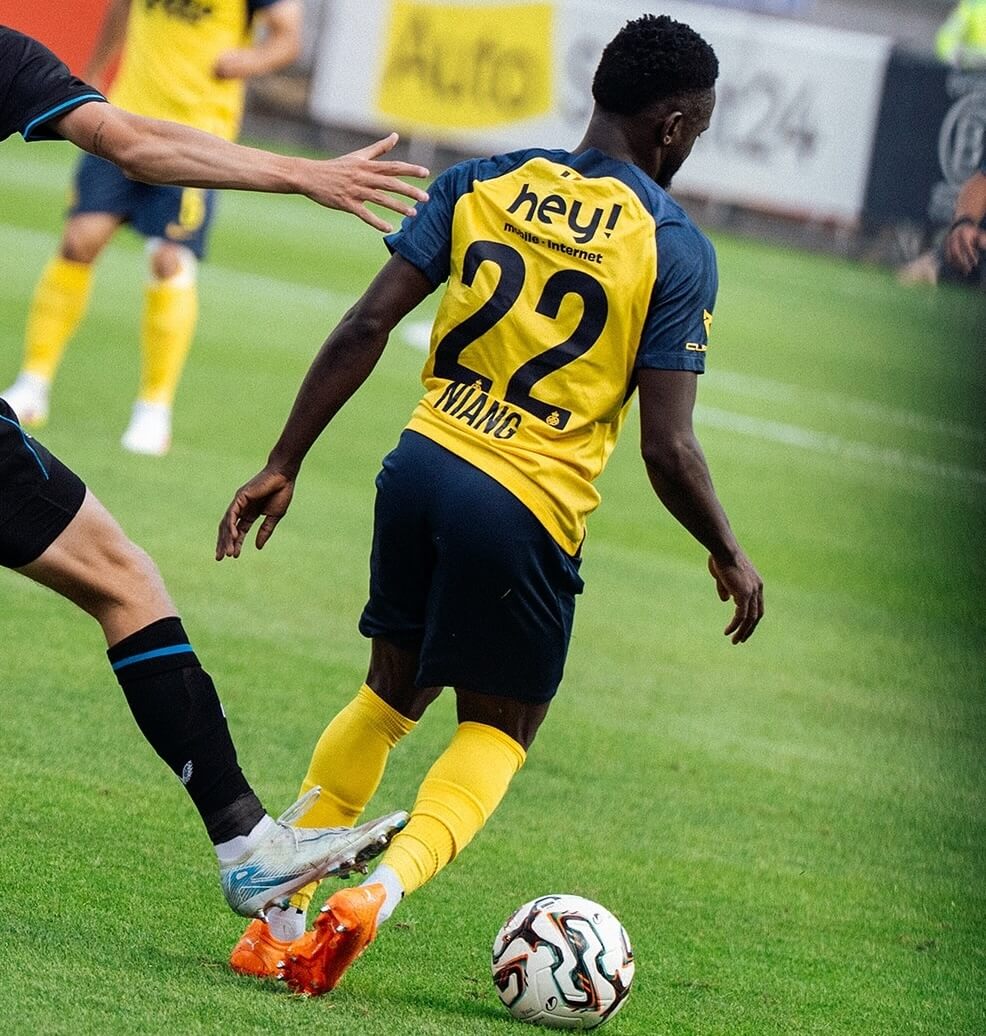 Soccer player from Belgian club Union Saint-Gilloise wearing the yellow and blue jersey number 22 dribbles the ball during a match 
