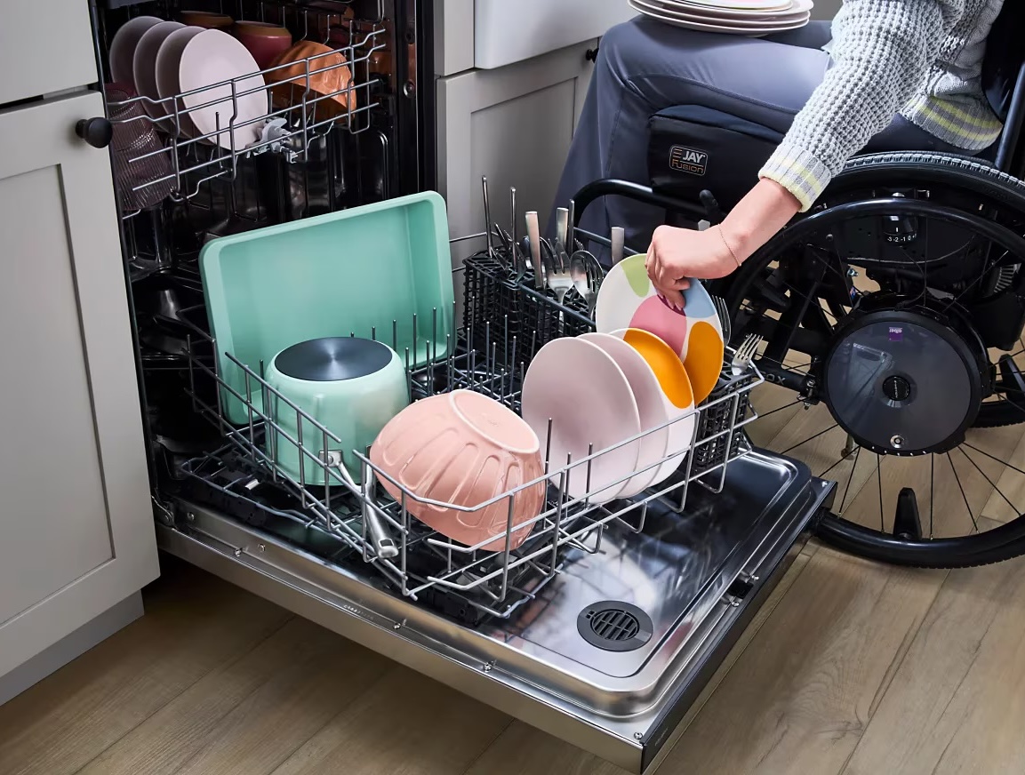 Person in wheelchair loading rotating lower rack in a Whirlpool dishwasher 